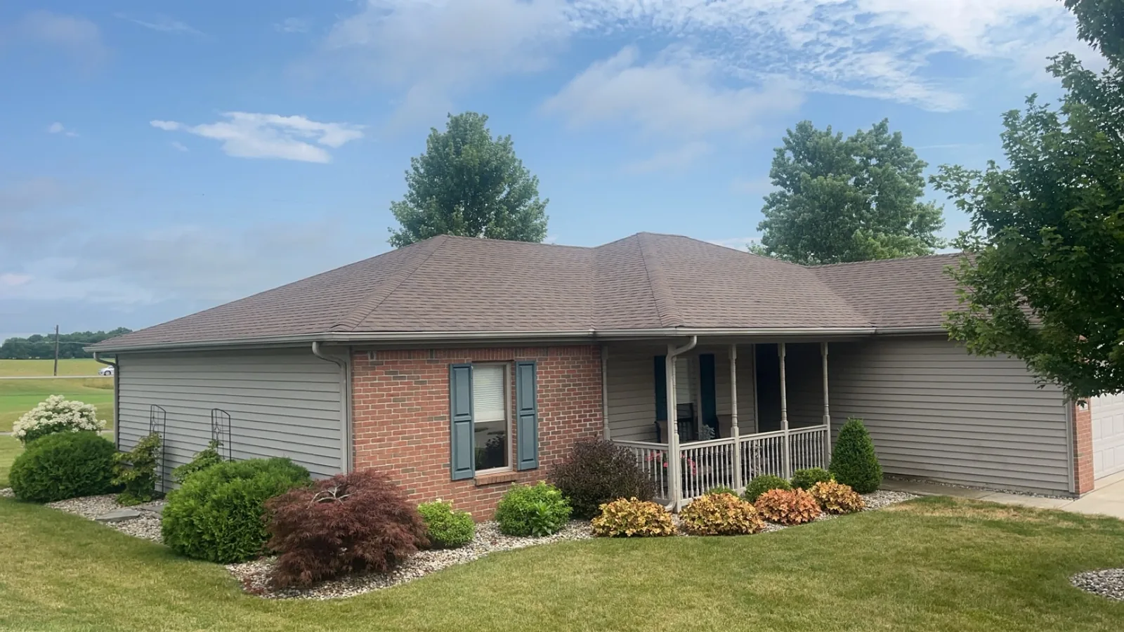 New asphalt shingle roof on a brick ranch home with custom landscaping in Northeast Indiana